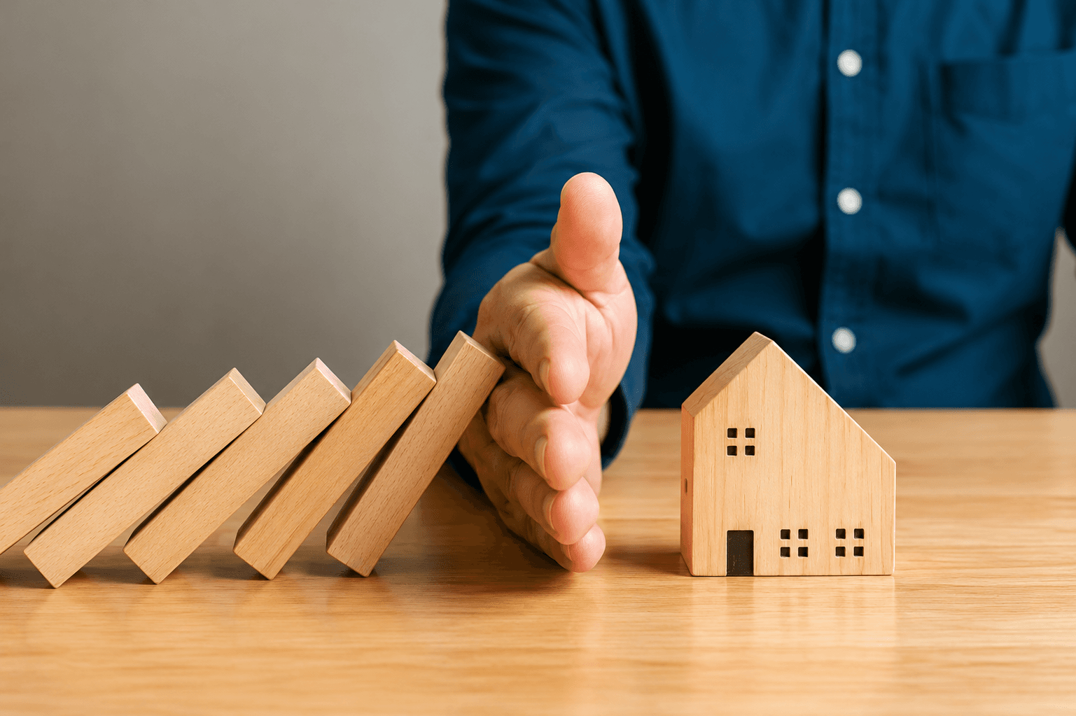 Hand holding a wooden house